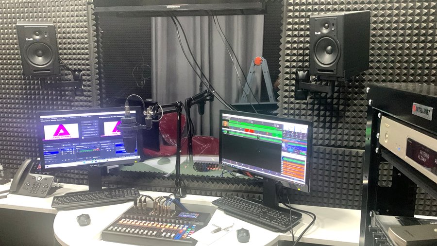 La postazione di regia con i doppi monitor, il mixer Yamaha e il microfono, pronti per andare in onda
